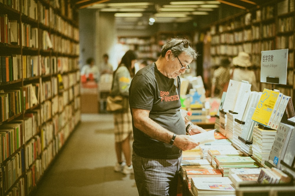 selective focus photography of standing person holding book