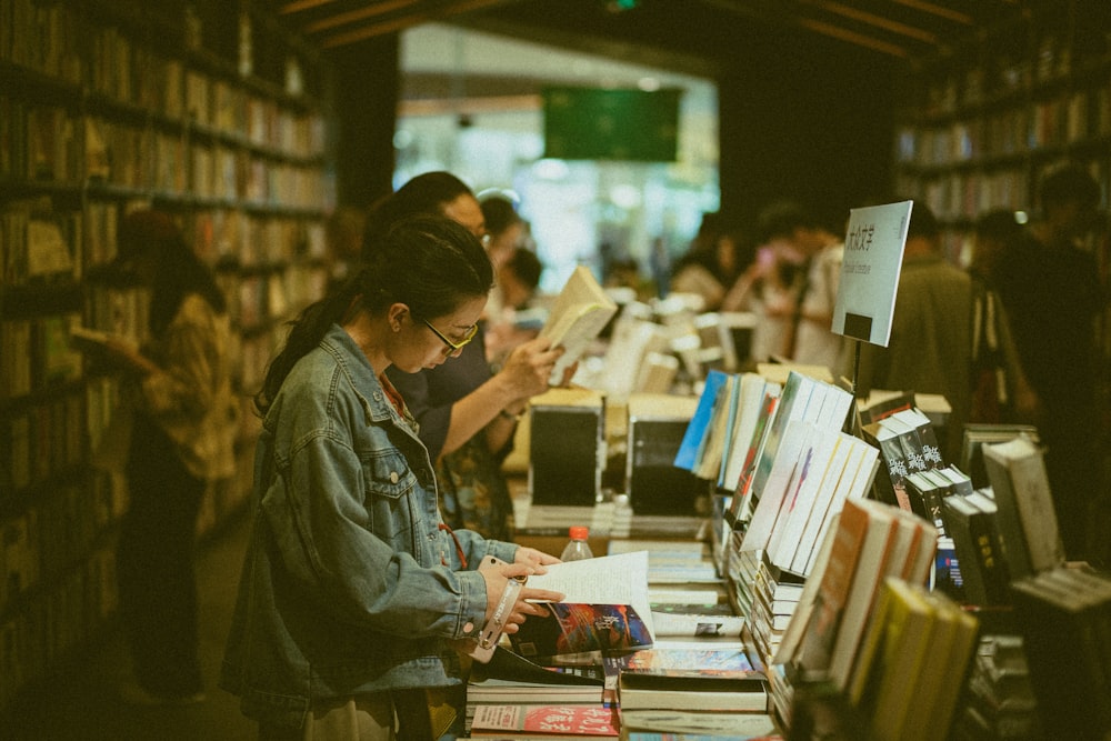 people standing and reading books