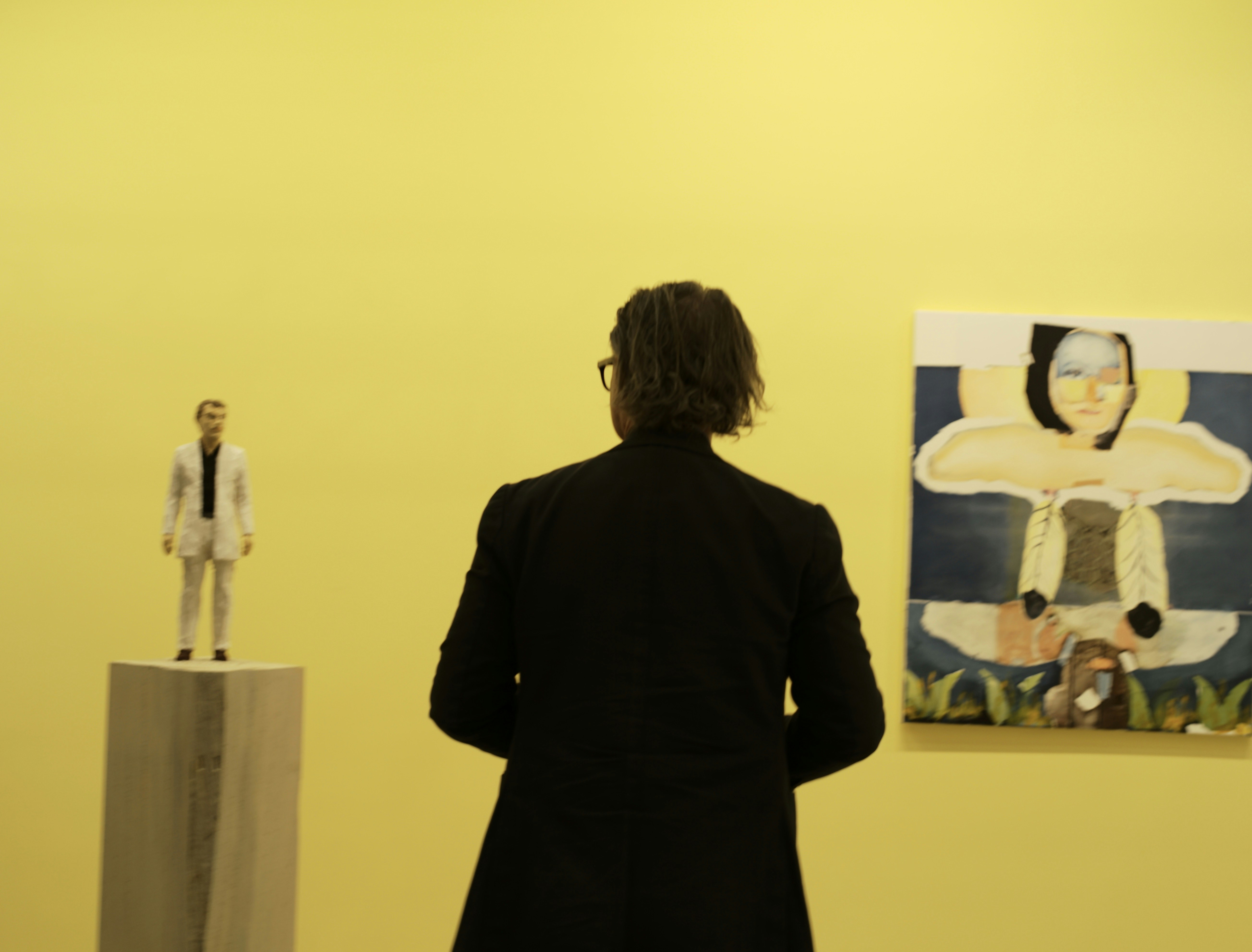 Curator walking through a gallery during an early preview appointment ahead of a busy exhibition season.