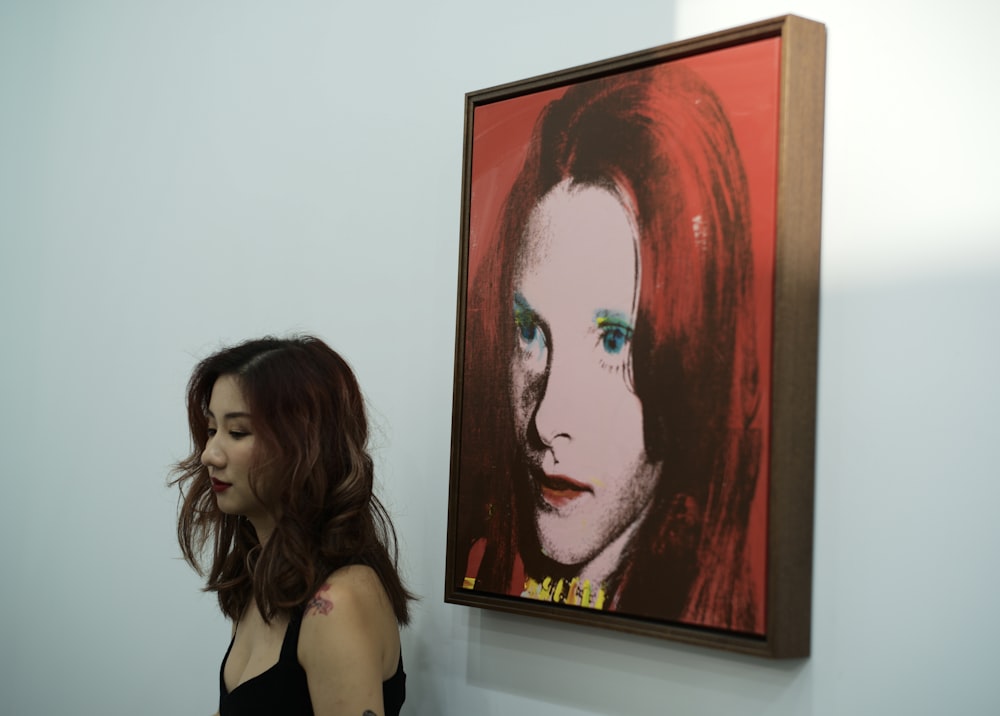 mulher de cabelos vermelhos que pinta perto da mulher em pé