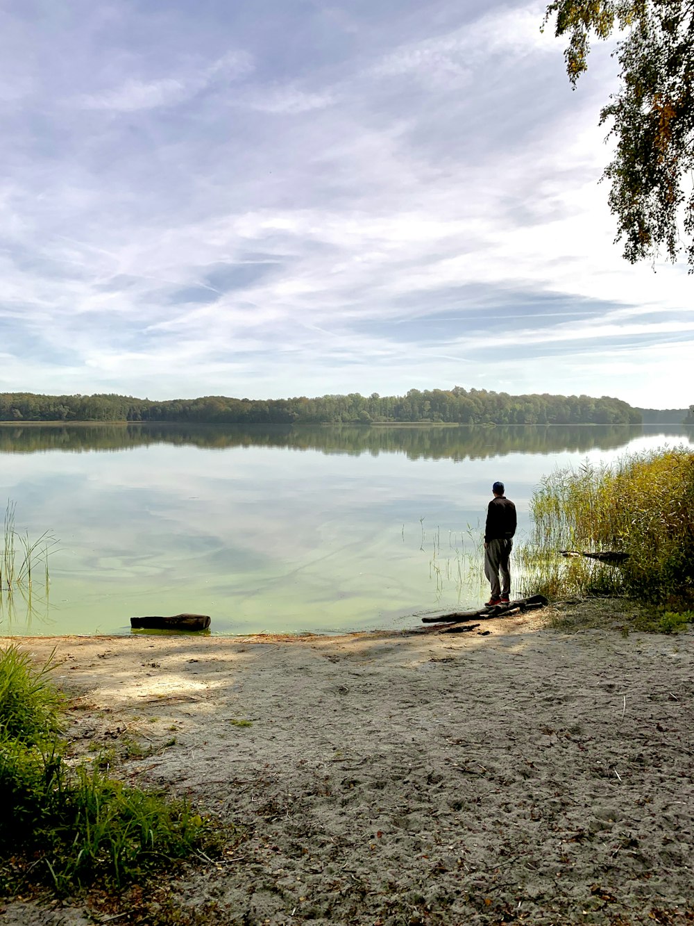 man standing front of lake during daytime