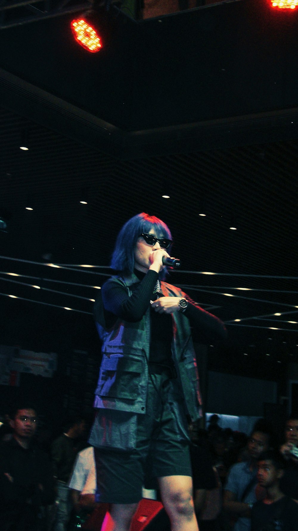 woman in black jacket sings on stage
