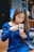 woman wearing blue dress holding white mug