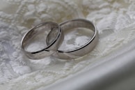 Close-up of wedding rings resting on a textured fabric, symbolizing commitment and elegance.