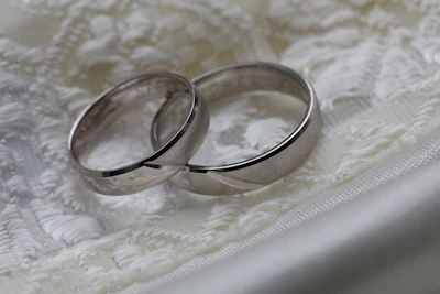 Elegant wedding rings resting on a navy blue and gold embroidered cloth symbolizing tradition.