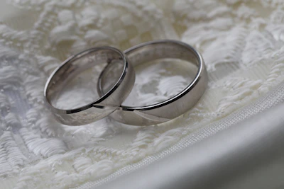 Close-up of wedding rings resting on delicate lace fabric