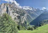 A panoramic view of the lush Fairy Meadows with towering Nanga Parbat peaks in the background.