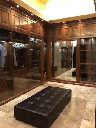 Elegant walk-in closet featuring sleek cabinetry and ambient lighting.