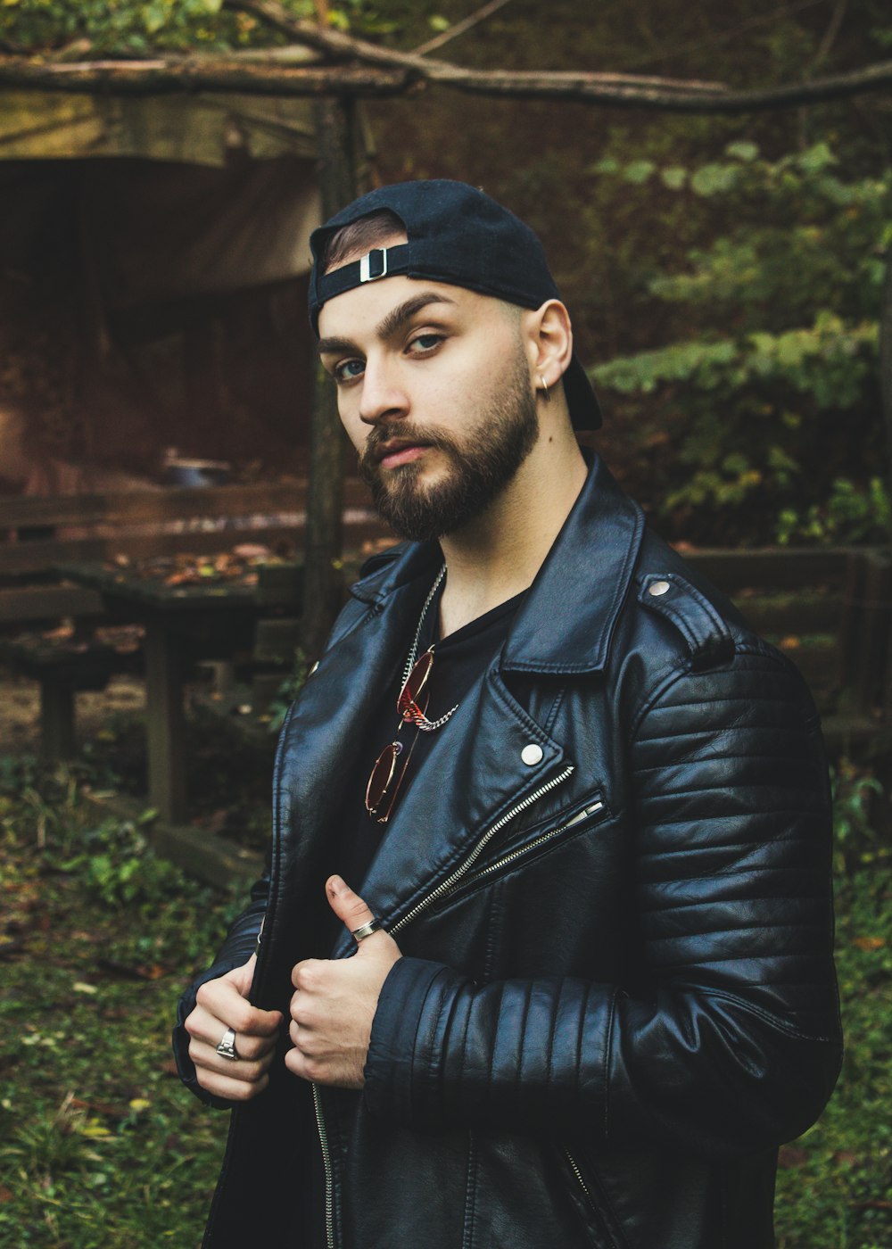 man wearing black leather jacket and hat