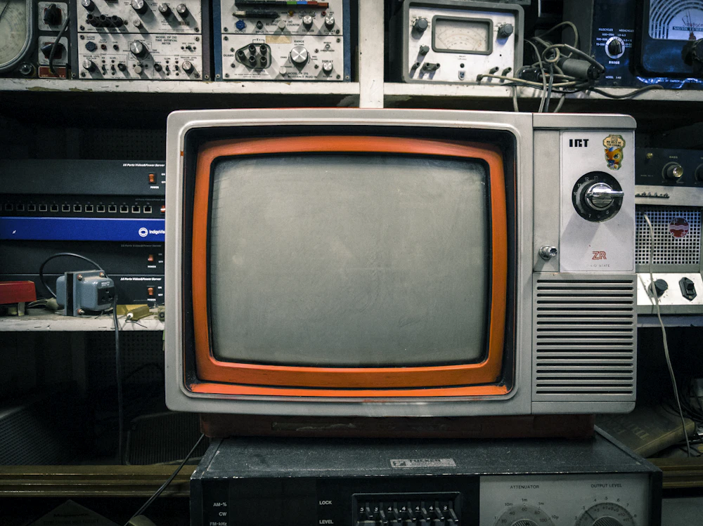 A vintage television on a repair bench surrounded by test equipment