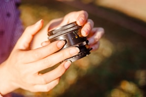 Hands holding a camera lens, ready to capture artistic moments.