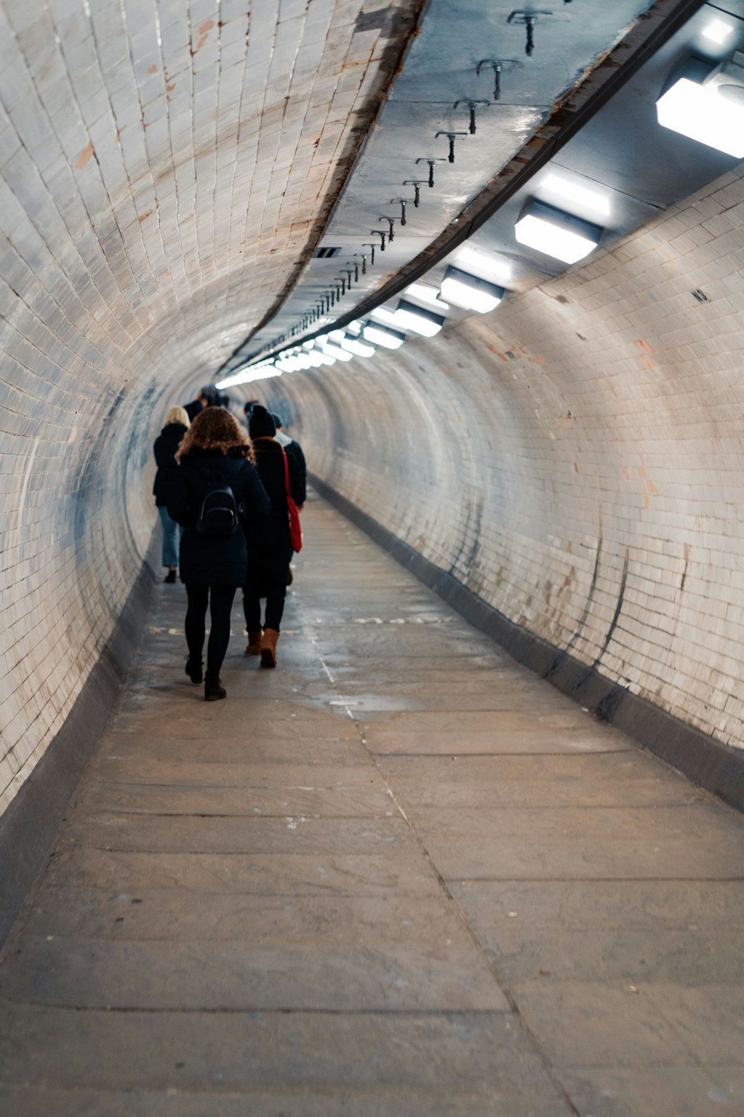people walking in lighted tunnel