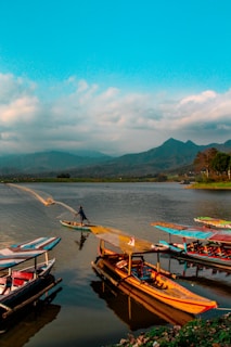 The serene waters of Lake Nokoué reflecting the sky, with fishermen in pirogues casting their nets.