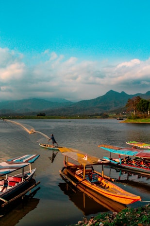 The serene waters of Lake Nokoué reflecting the sky, with fishermen in pirogues casting their nets.