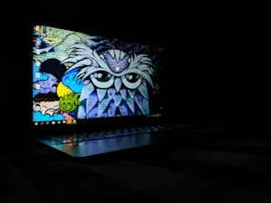 Close-up of a laptop screen being fixed on a mobile repair van with vibrant mural art on the side.