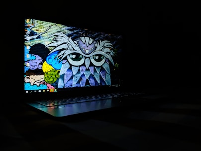 Close-up of a laptop screen being fixed on a mobile repair van with vibrant mural art on the side.