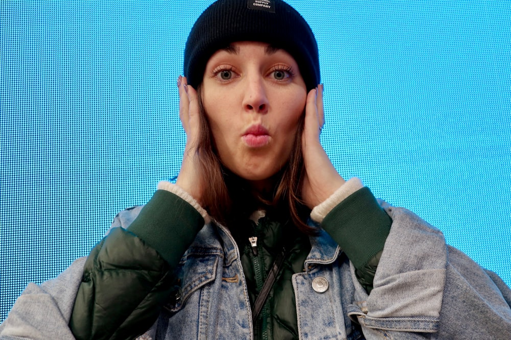 woman wearing grey denim jacket and green beanie