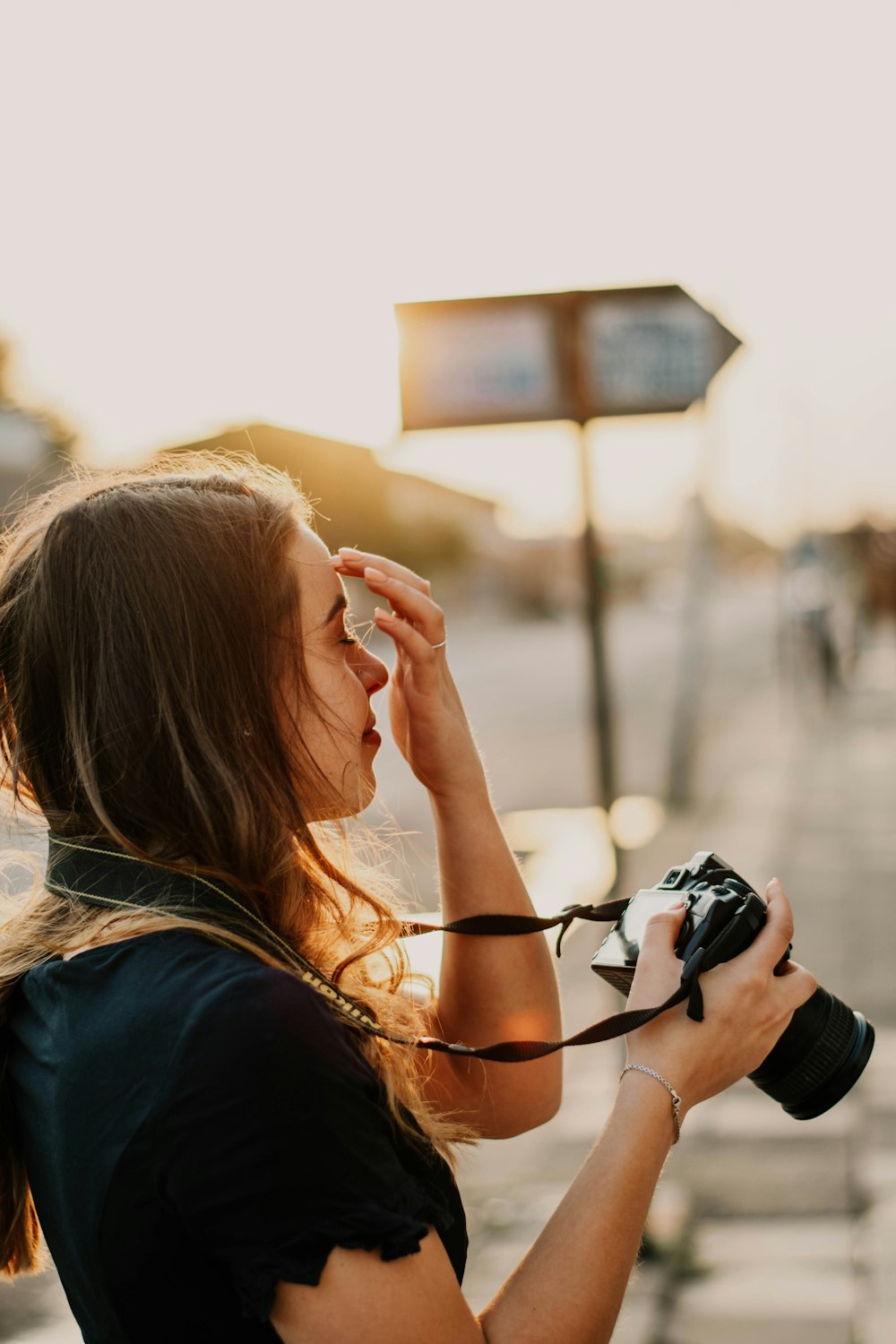 woman in black shirt holding DSLR camera