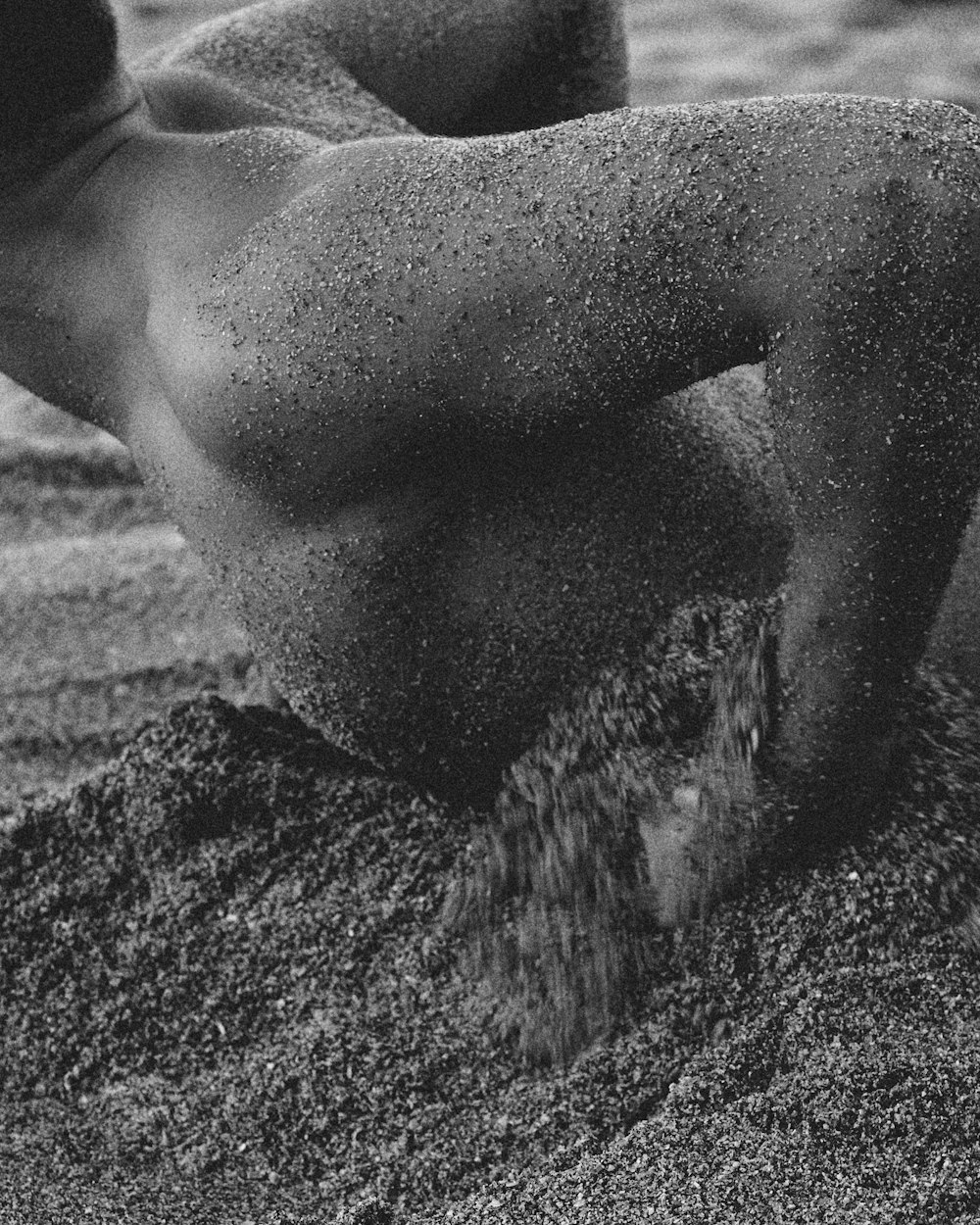 grayscale photo of man lying on seashore