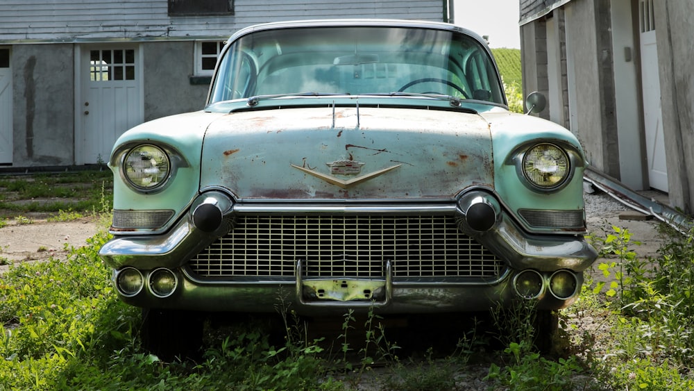 classic blue vehicle parked beside wall