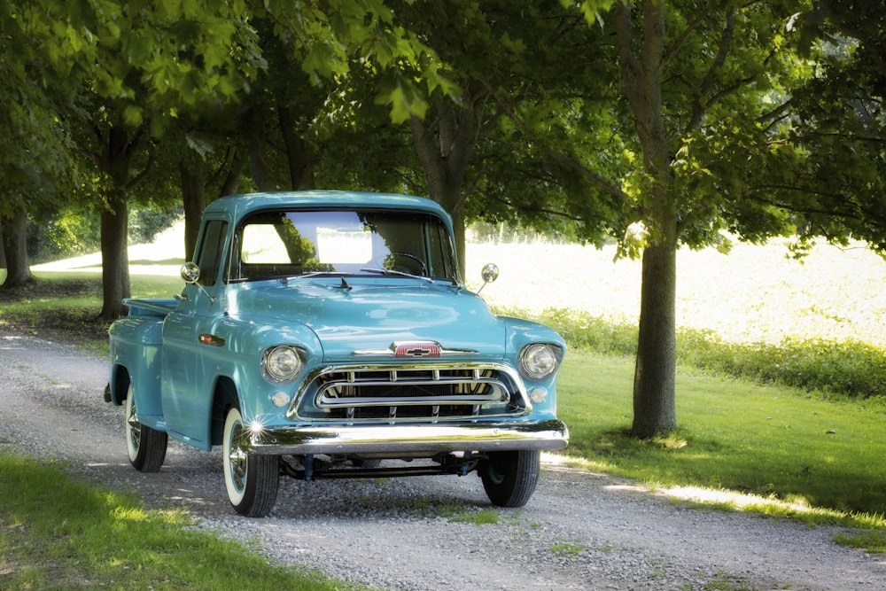 classic blue single cab pickup truck parked on dirt road
