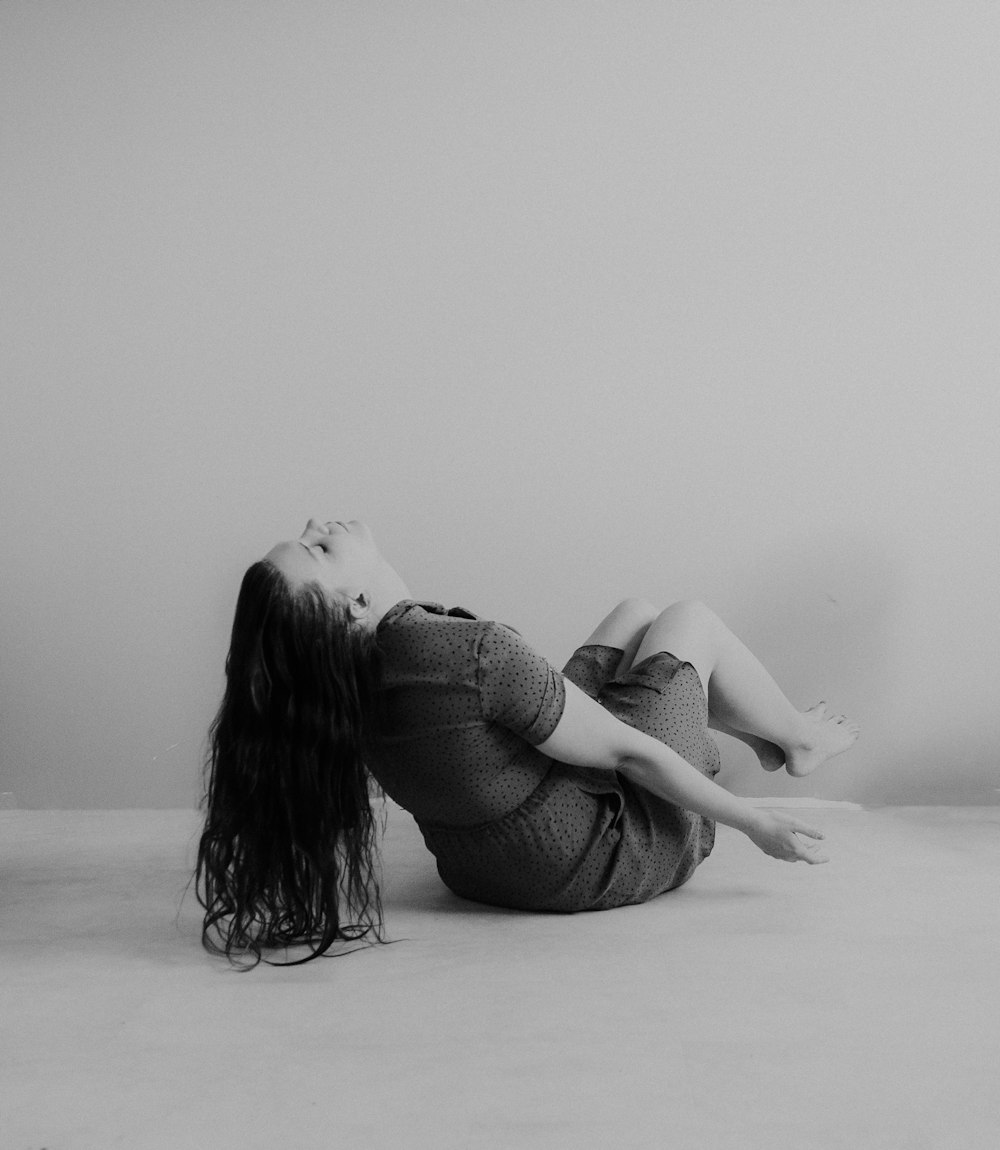 a woman laying on the floor with her legs crossed