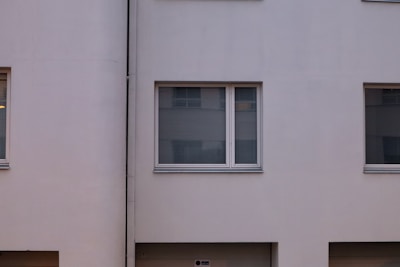 An elegant residential building with a minimalist facade and large windows.