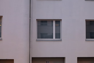 An elegant residential building with a minimalist facade and large windows.