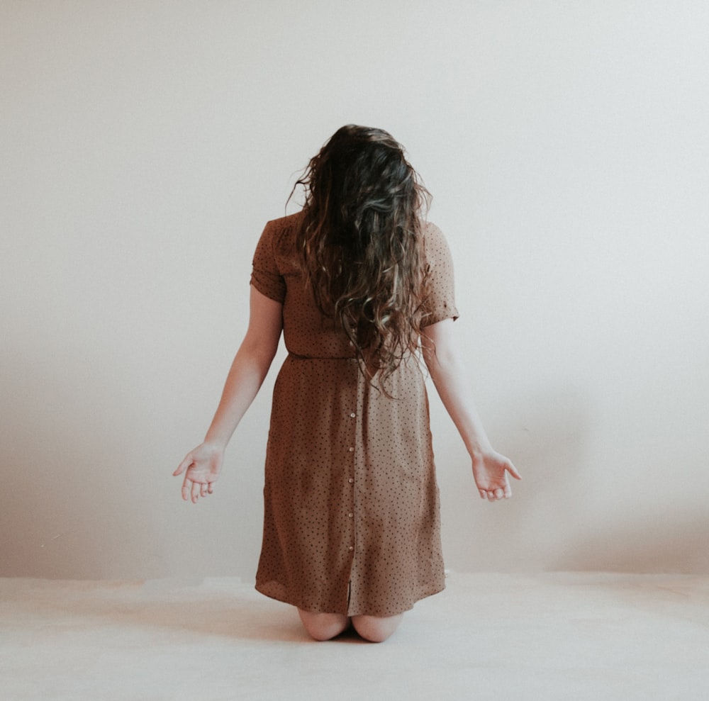 kneeling woman wearing brown dress