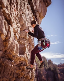 woman climbing on rock formation