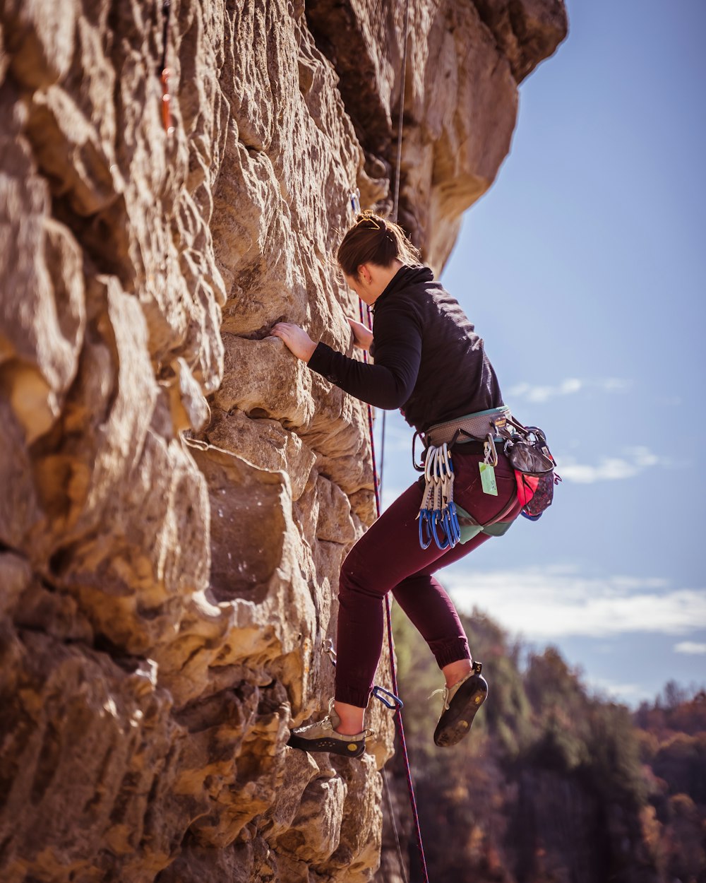 woman climbing on rock formation