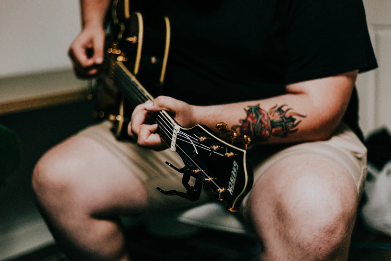 Illustrative photograph of a person playing guitar