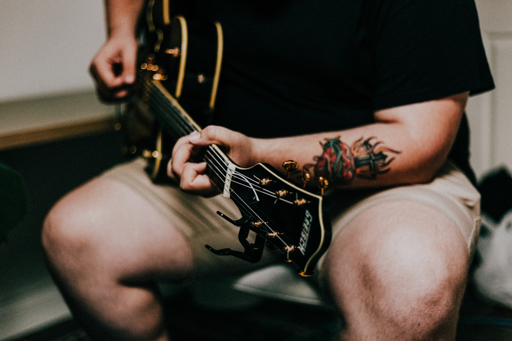 Mann spielt akustische Gitarre