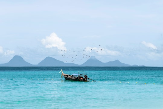 brown wooden boat on body of water during daytime in Phang Nga Bay Thailand