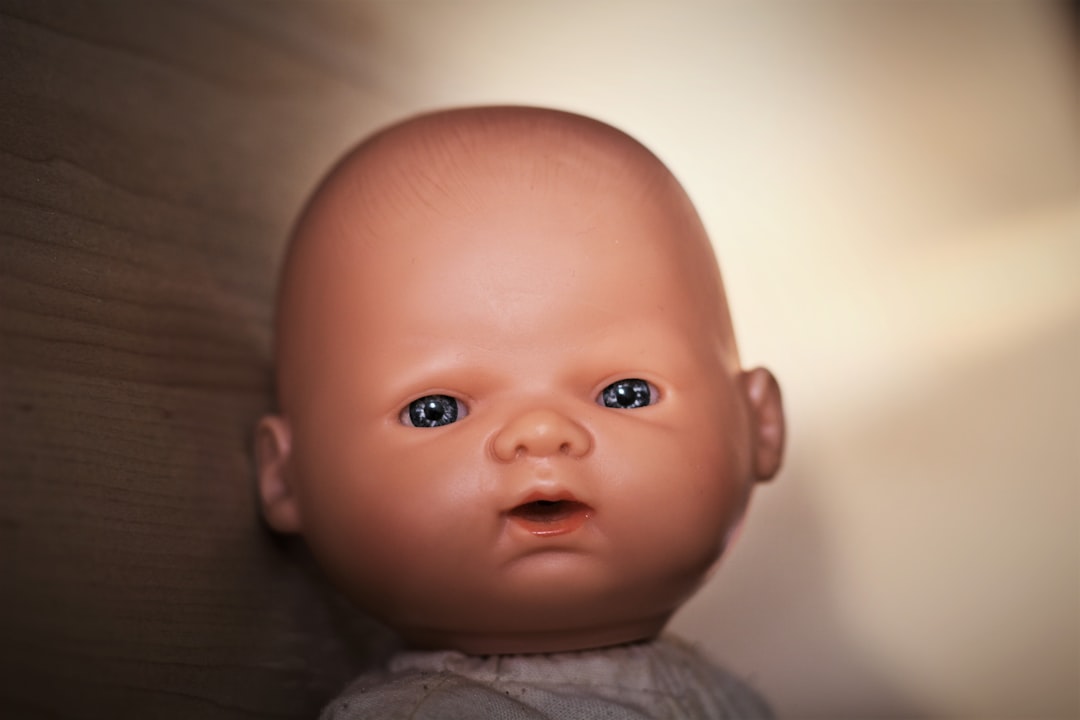 selective focus photography of baby doll's face