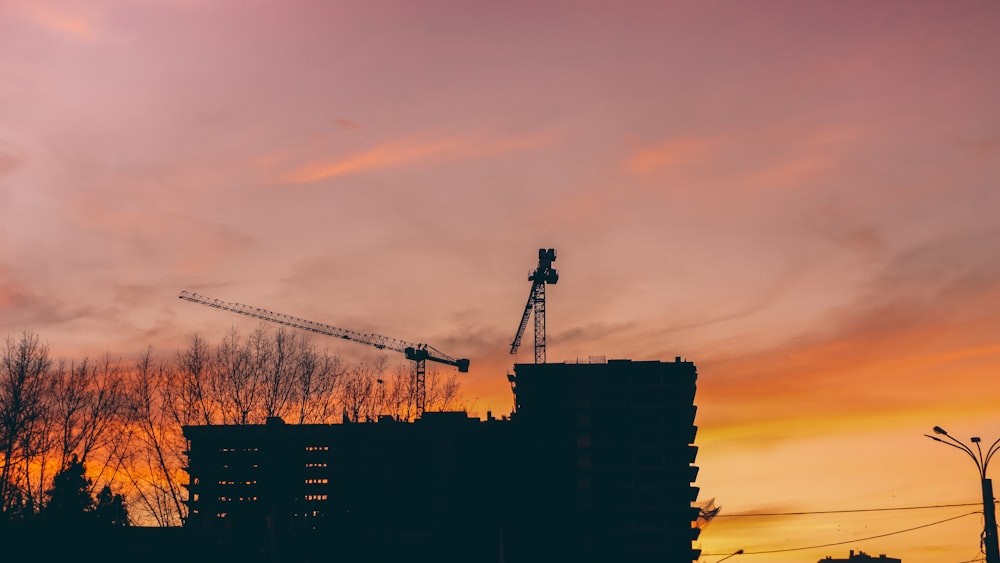 silhouette of building under orange clouds