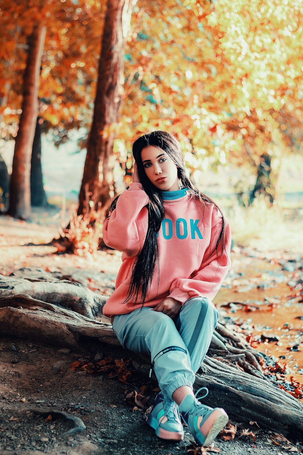 selective focus photography of girl sits on roots during daytime