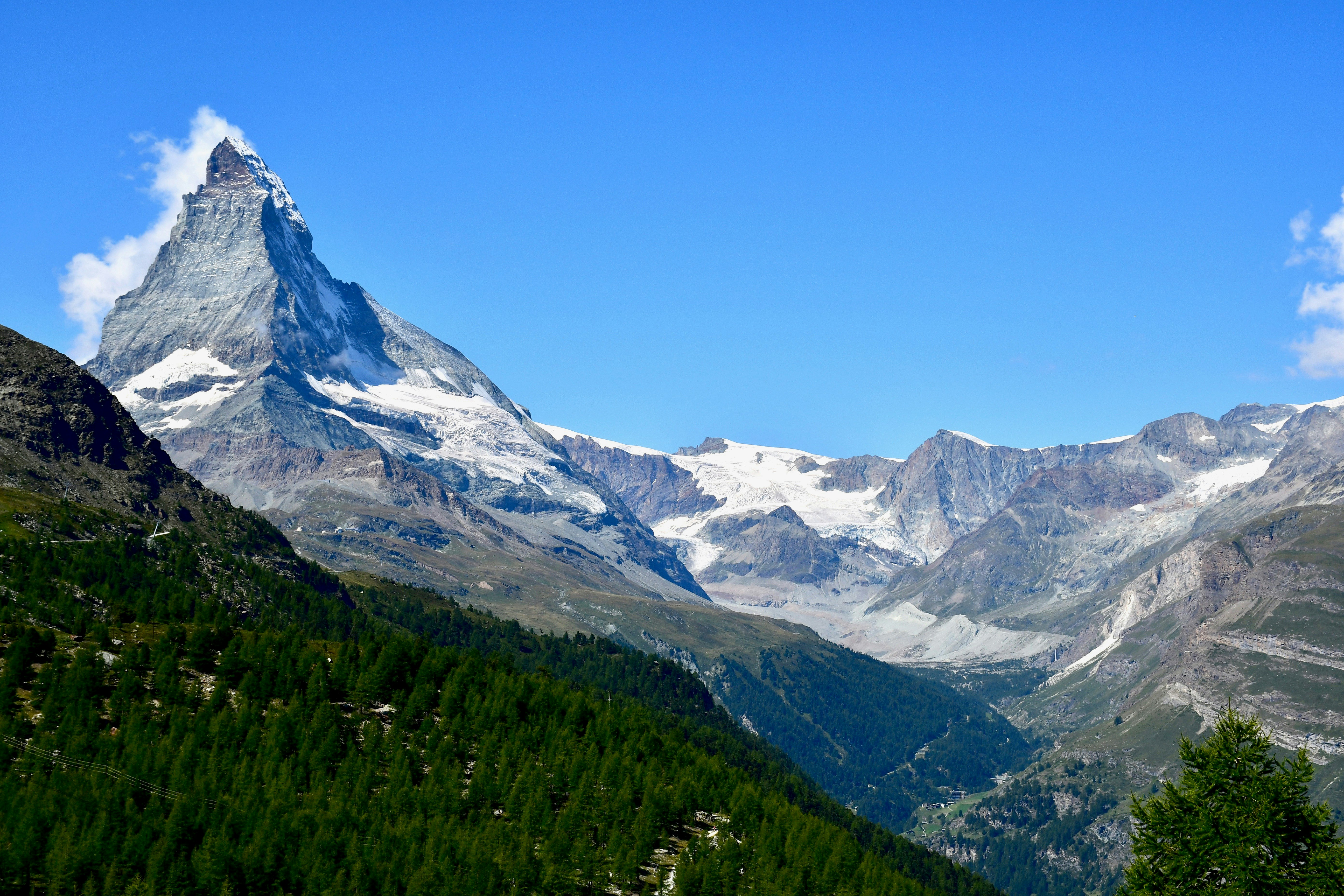 green, brown, and white mountains under blue sky