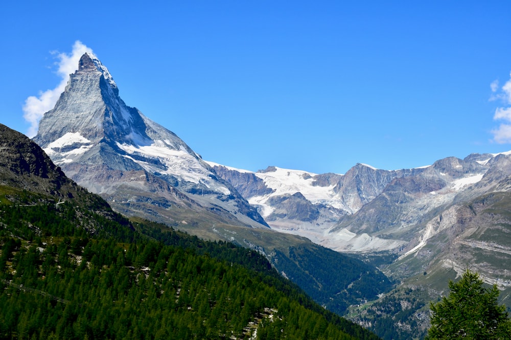 green, brown, and white mountains under blue sky