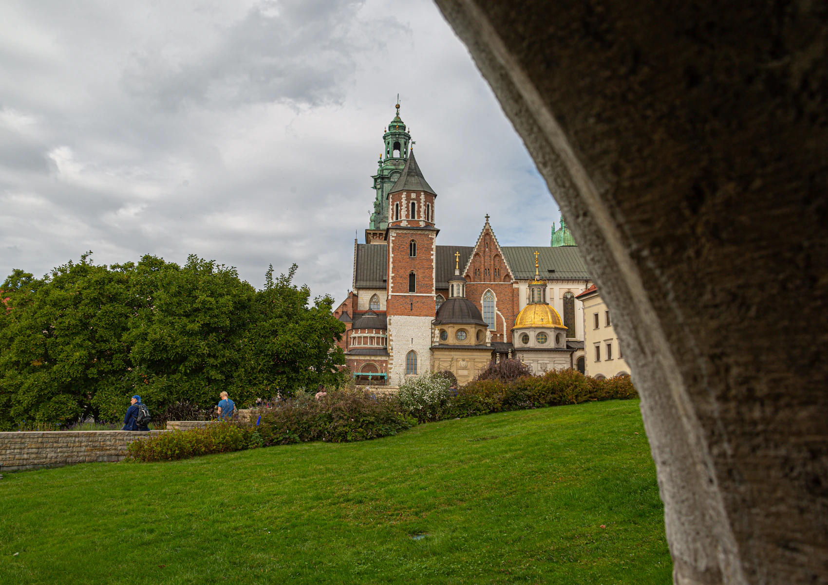 Wawel Cathedral framed by a stone arch within the castle grounds in Kraków