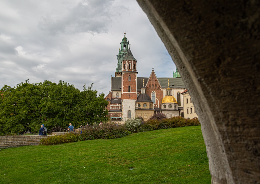 few people walking near Wawel Cathedral in Krakow Poland under white and blue sky during daytime