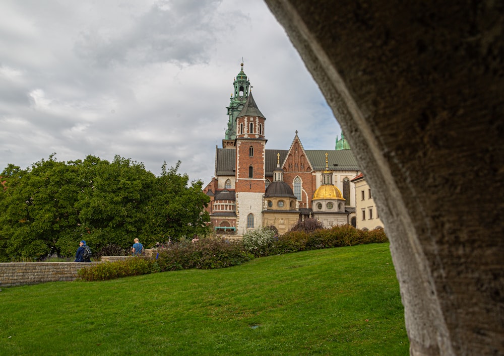 wenige Menschen, die tagsüber in der Nähe der Wawel-Kathedrale in Krakau, Polen, unter weißem und blauem Himmel spazieren gehen