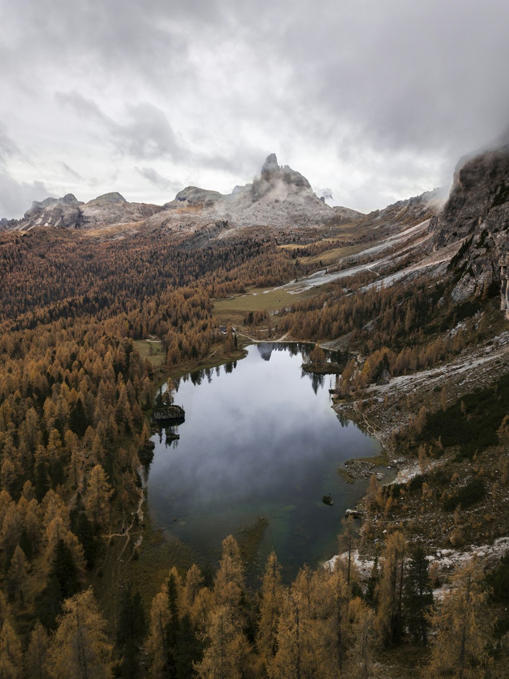 Vue aérienne du lac entouré d’arbres et de montagnes