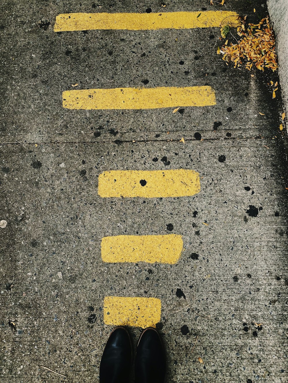 a pair of black shoes standing on a sidewalk