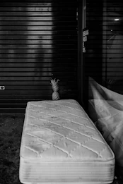 grayscale photography of ottoman beside mirror