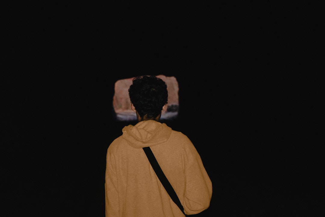 walking person wearing hoodie and carrying black bag