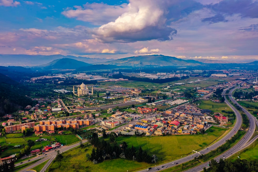 aerial photography of city buildings, mountains, and road during daytime