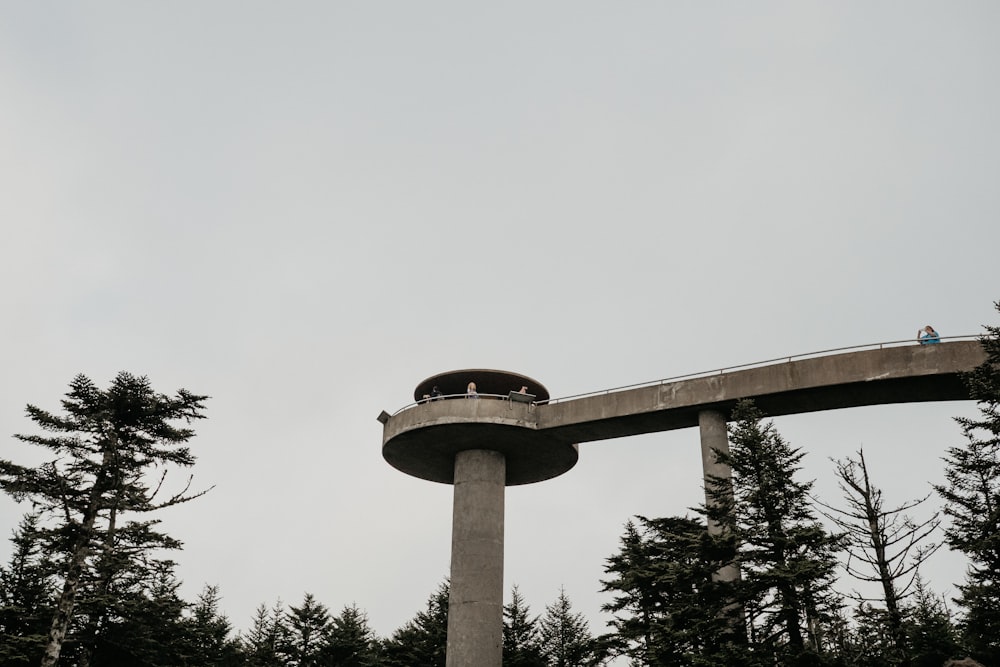 grayscale photography of concrete tower with bridge