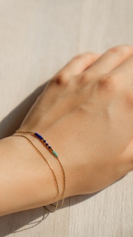 A close-up of a stylish bracelet featuring Hebrew letters, resting on a rustic wooden table with soft natural light.