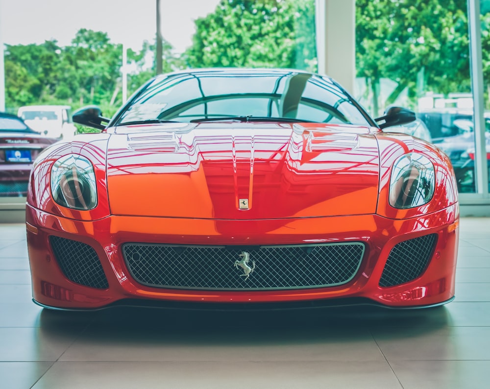 Un coche deportivo rojo estacionado en una sala de exposición